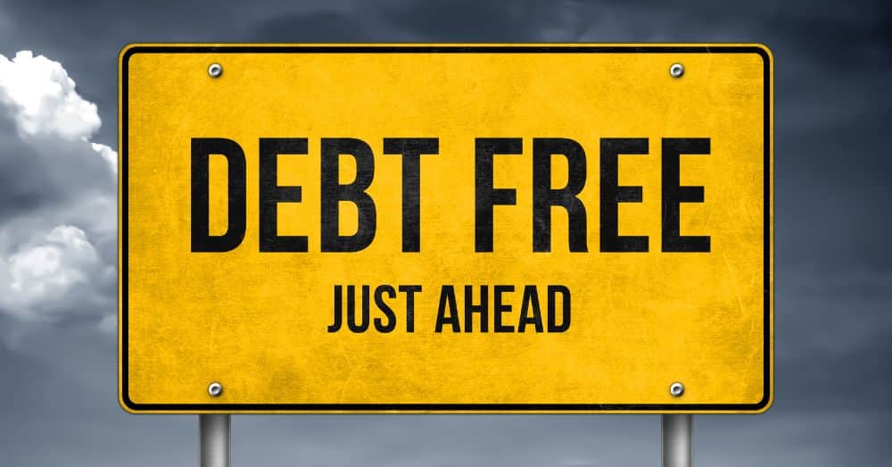 yellow road sign with words debt free just ahead