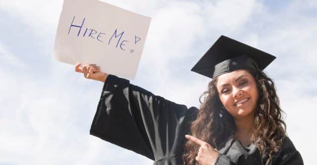 graduate holding sign that reads hire me