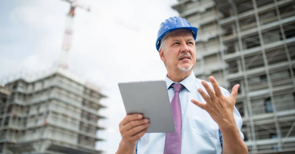 man in hardhat with tablet counting on his fingers