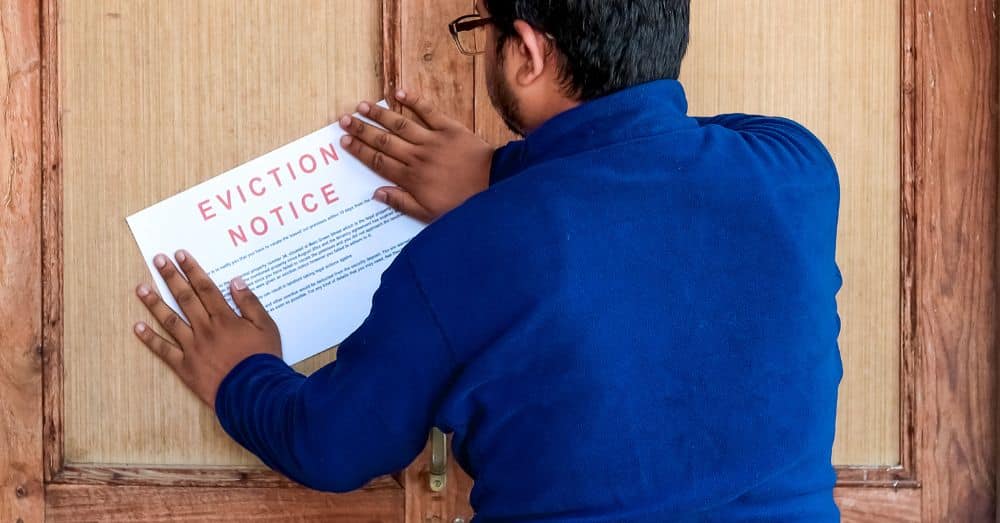 person posting eviction notice on door